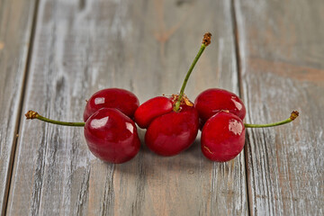 Nature's Oddity: ugly, irregularly shaped cherry stands out against a rustic wooden backdrop
