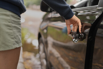 Close-up view of woman opening car door standing on road
