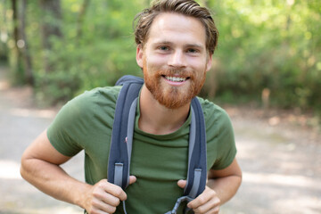 hiking man portrait with backpack walking in nature