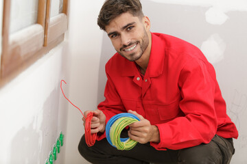 young smiling electrician with bunch of wires