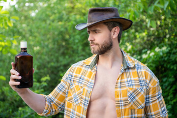 cowboy man offer whiskey outdoor. photo of cowboy man with whiskey. cowboy man