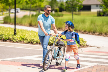 dad and son duo pedaling through picturesque landscape. dad guiding his son first bike ride. Guided biking experience. dad and son enjoying fun bike outing. dad and son on biking adventure