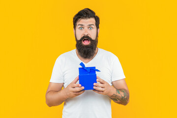 shocked man with present box isolated on yellow. man with present box in studio.