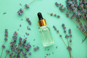 Flat lay composition with lavender flowers and lavender oil on mint background
