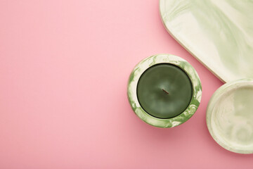 Interior candle in plaster candlestick on pink background.