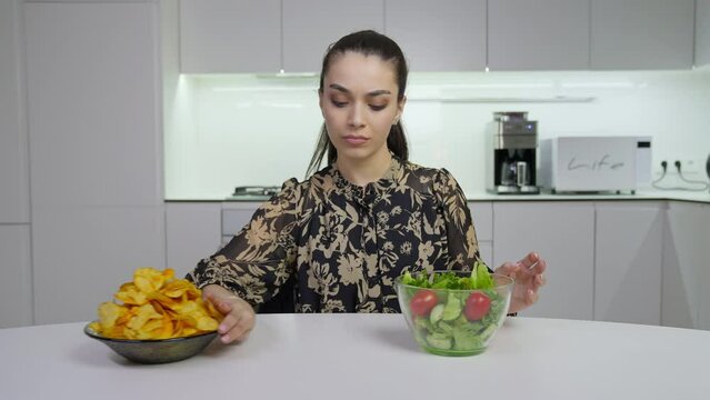 Girl pushes aside plate with unhealthy food and takes healthy one
