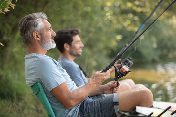 two male friends are fishing together