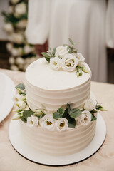 Obraz na płótnie Canvas Festive two-tiered white cake with flowers