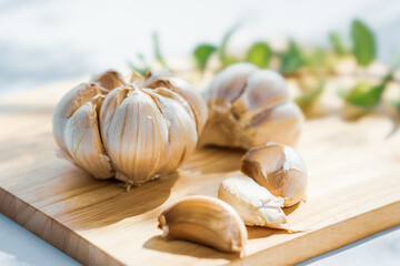 Garlic cloves on rustic table on wooden board. Fresh peeled garlics and bulbs
