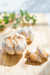 Garlic cloves on rustic table on wooden board. Fresh peeled garlics and bulbs