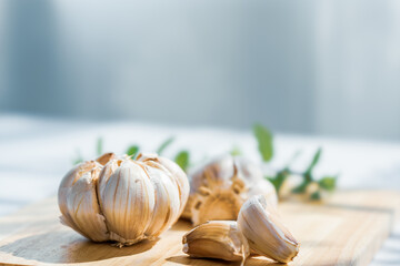Garlic cloves on rustic table on wooden board. Fresh peeled garlics and bulbs