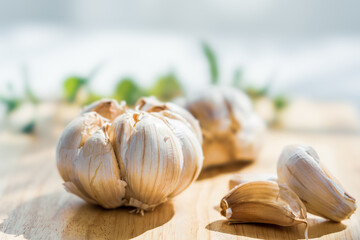 Garlic cloves on rustic table on wooden board. Fresh peeled garlics and bulbs