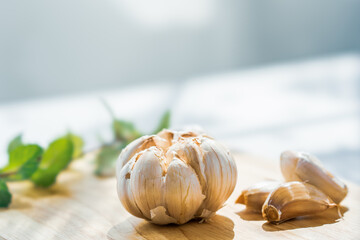 Garlic cloves on rustic table on wooden board. Fresh peeled garlics and bulbs