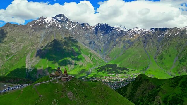 trinity monastery of kazbegi opposite the mountains of georgia, view from a flying drone - stock video georgia
