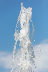 Fountain splashes against the blue sky. Background