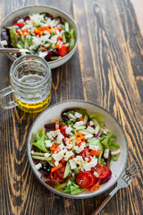 Griechischer Salat mit Feta in einer Schüssel und ein Glas Bier auf einem rustikalen braunen Holz Tisch. Sommer.
