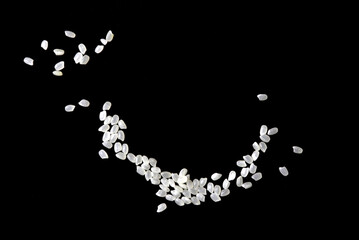 Heaps of uncooked Japanese short grain rice piled together isolated on black background.	
