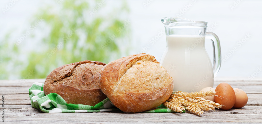 Wall mural Homemade bread and milk on wooden table