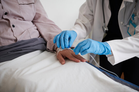 Closep image of doctor in medical gloves inserting IV catheter