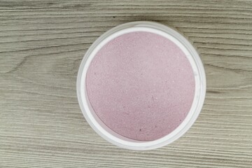 Pink protein powder in wooden background