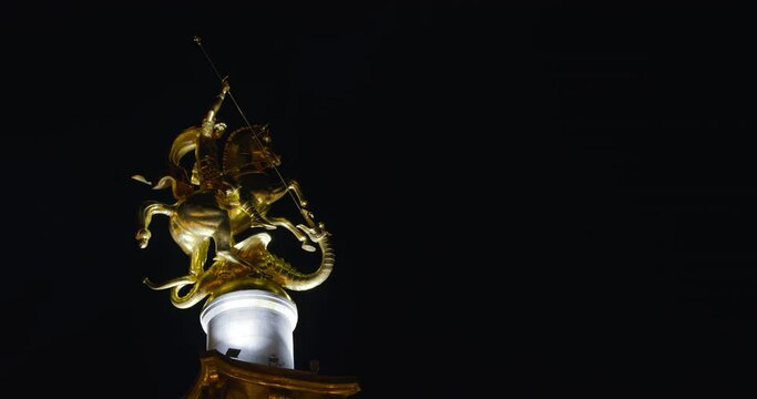 Tbilisi Georgia. Night View Of Illuminated Liberty Monument Depicting St George Slaying Dragon In Freedom Square In City Center. Black Background.