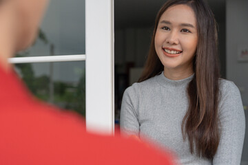 Happy smiling woman receives boxes parcel from courier in front house. Delivery man send deliver express. online shopping, paper containers, takeaway, postman, delivery service, packages