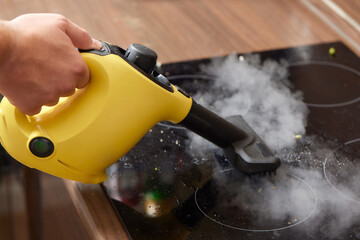 Cleaning of induction cooker with steam cleaner.