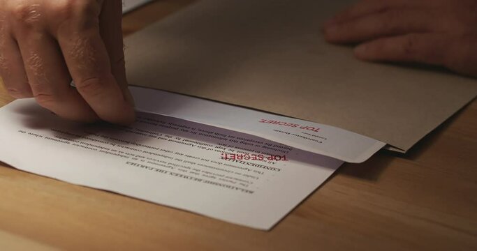 Agent pick-up confidential important documents with seal Top Secret, close-up shot