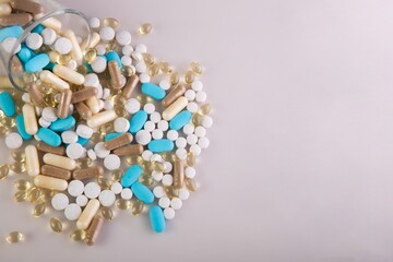 Medical pills scattered on a pink surface