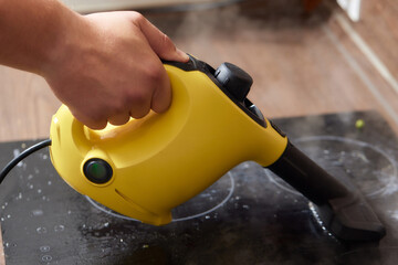 Cleaning of induction cooker with steam cleaner.
