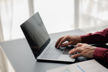 A business man working in a private room, He is typing on a laptop keyboard, He uses a messenger to chat with a partner. Concept of using technology in communication.