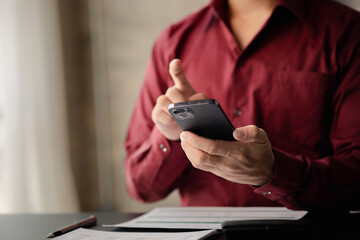 A person holds a mobile phone to use social media on a smartphone, communicating via the Internet on a smartphone. The concept of using technology in communication..