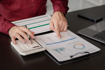 Business man pointing to a pie chart document showing company financial information, He sits in her private office, a document showing company financial information in chart form. Financial concepts.