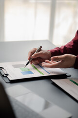 Business man pointing to a pie chart document showing company financial information, He sits in her private office, a document showing company financial information in chart form. Financial concepts.