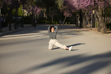 Young and beautiful woman, Hispanic, brown hair, with striped sweater, linen pants, bending down...