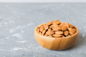 Fresh healthy Almond in bowl on colored table background. Top view