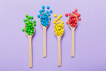 delicious colorful sweet candies on spoon on colored background . Confectionery decor top view with copy space
