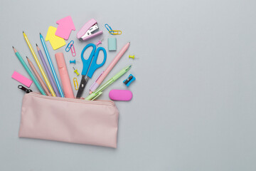 Pink pencil case with school stationery on color backgroung, top view - obrazy, fototapety, plakaty