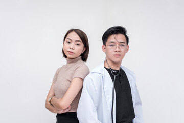 Portrait of professional man, doctor, physician, and woman posing side by side looking fierce and serious. Isolated on a red background.