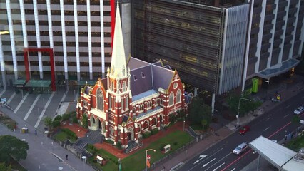 Static shot capturing the architectural details of iconic landmark Albert street uniting church from above with traffics on Ann street, downtown Brisbane city.