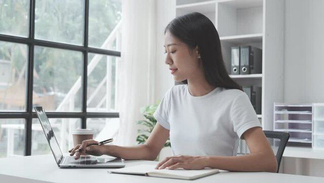 Young Asian woman university student satisfied with learning english language during online courses via laptop computer, learning online with webinar, video tutorial, internet lessons