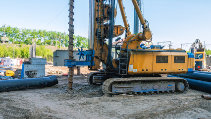 Installation for drilling wells on a crawler. Drilling machine on the construction site. Drilling holes in the ground. - obrazy, fototapety, plakaty