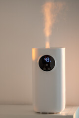 Modern humidifier at home, moistens dry air in living room. Humidification, comfortable living...