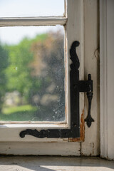 old beautiful hinge on the surface of the window. close-up