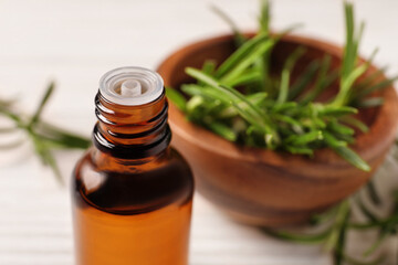 Bottle with essential oil against blurred background, closeup. Space for text