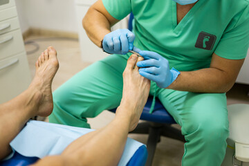An unrecognizable podiatrist cuts the toenails during the pedicure procedure. Professional pedicure...