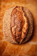 Freshly baked loaf of artisanal bread with a light dusting of flour on its golden brown crust