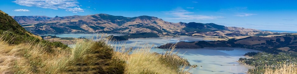 Outdoor landscape, showing rolling hills with sandy and grassy terrain with a lake
