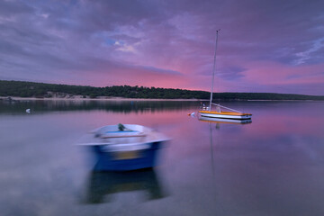 Boat on the lake at sunset. long exposure. Vivid colors.