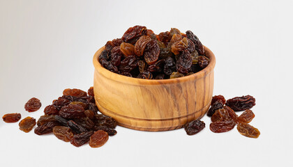 Raisins in wooden bowl isolated on white background.